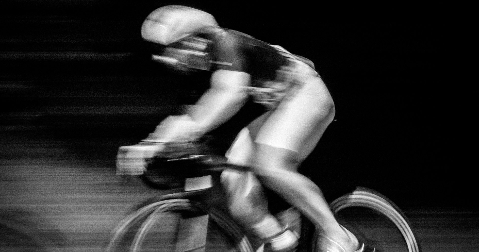 Cyclist in an aerodynamic position, captured with motion blur